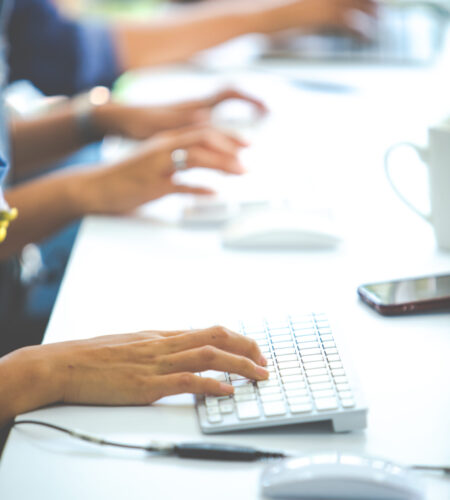 Business woman use computer for online shopping and typing on keyboard at Home office with white cup of coffee